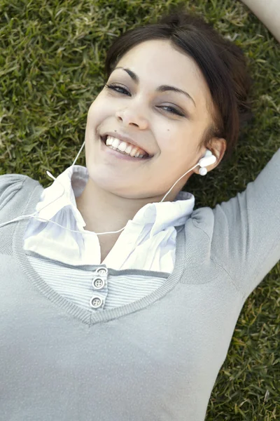 Retrato de uma jovem mulher ouvindo música em seus fones de ouvido — Fotografia de Stock