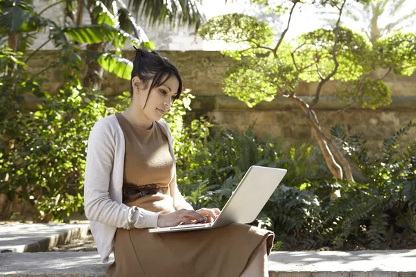 Jovem mulher profissional usando um computador portátil — Fotografia de Stock