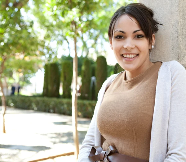 Attractive young woman leaning on a column — Stock Photo, Image