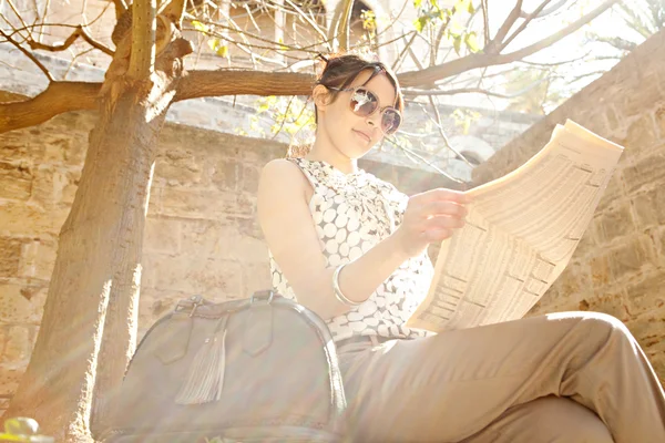 Attractive young businesswoman reading a financial newspaper — Stock Photo, Image