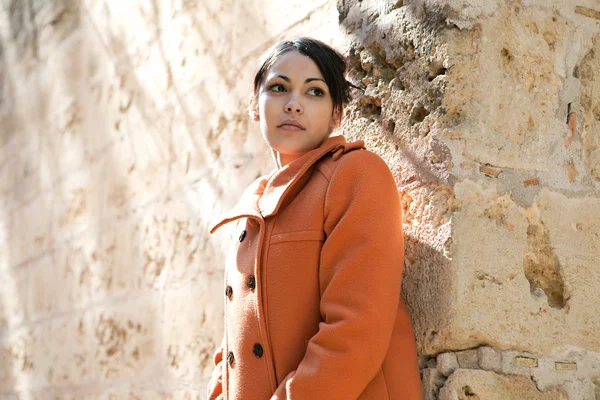 Jonge vrouw die draagt een oranje jas — Stockfoto
