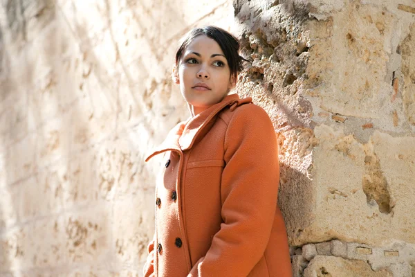 Young woman wearing an orange coat — Stock Photo, Image