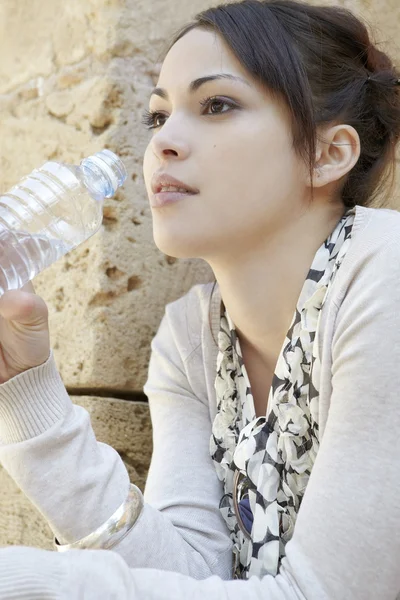 Portret van een jonge zakenvrouw houden een fles mineraalwater. — Stockfoto