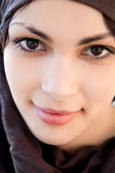Mujer joven musulmana con una bufanda en la cabeza y sonriendo a la cámara — Foto de Stock