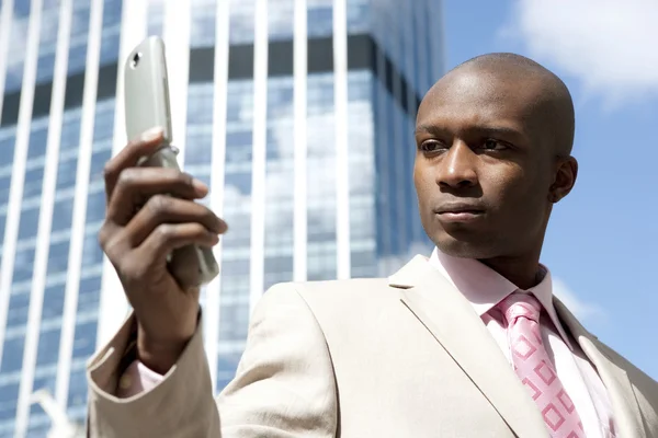 Close up van een zakenman met behulp van een mobiele telefoon in het financiële district. — Stockfoto