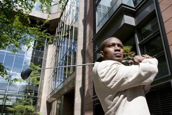 Primer plano de un hombre de negocios jugando al golf en el distrito financiero . — Foto de Stock