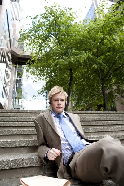 Young businessman listening to music with headphones — Stock Photo, Image