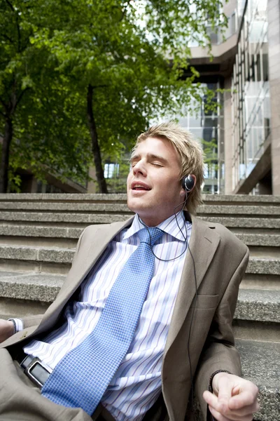 Jonge zakenman zingen naar muziek met een hoofdtelefoon — Stockfoto