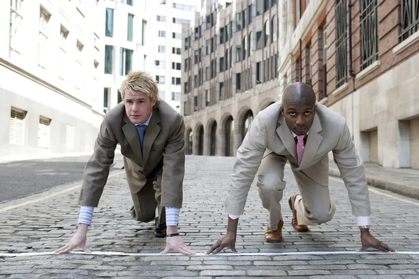 Dwóch biznesmenów w położeniu gotowy do rozpoczęcia wyścigu w finansowej dzielnicy. — Zdjęcie stockowe