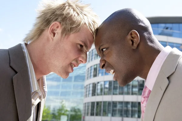 Dois homens de negócios dirigem-se a cabeça em uma discussão na cidade . — Fotografia de Stock