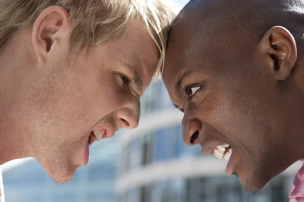 Two businessmen head to head having an argument in the city. — Stock Photo, Image