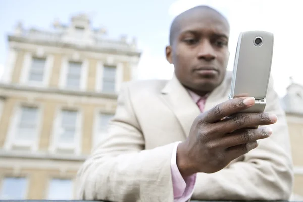 Empresario de mensajes de texto en un teléfono celular al aire libre — Foto de Stock