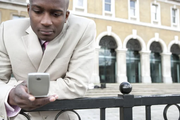 Empresario de mensajes de texto en un teléfono celular al aire libre — Foto de Stock