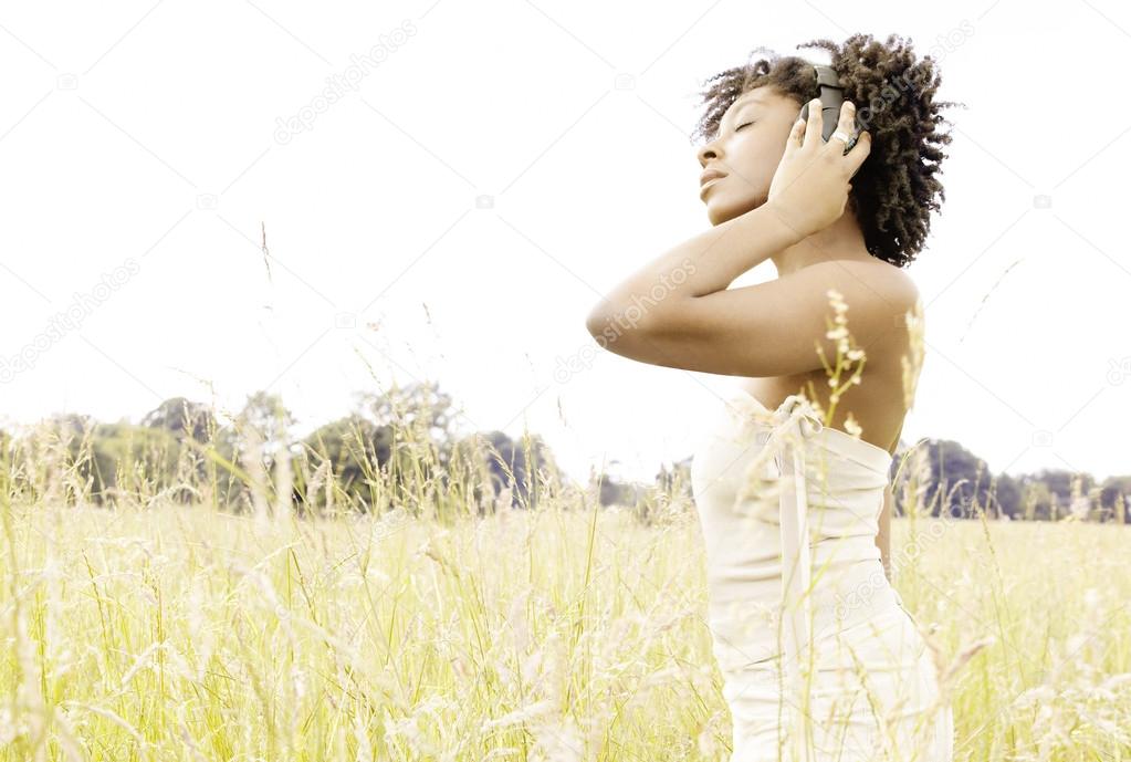 Attractive black woman enjoying listening to music with her headphones