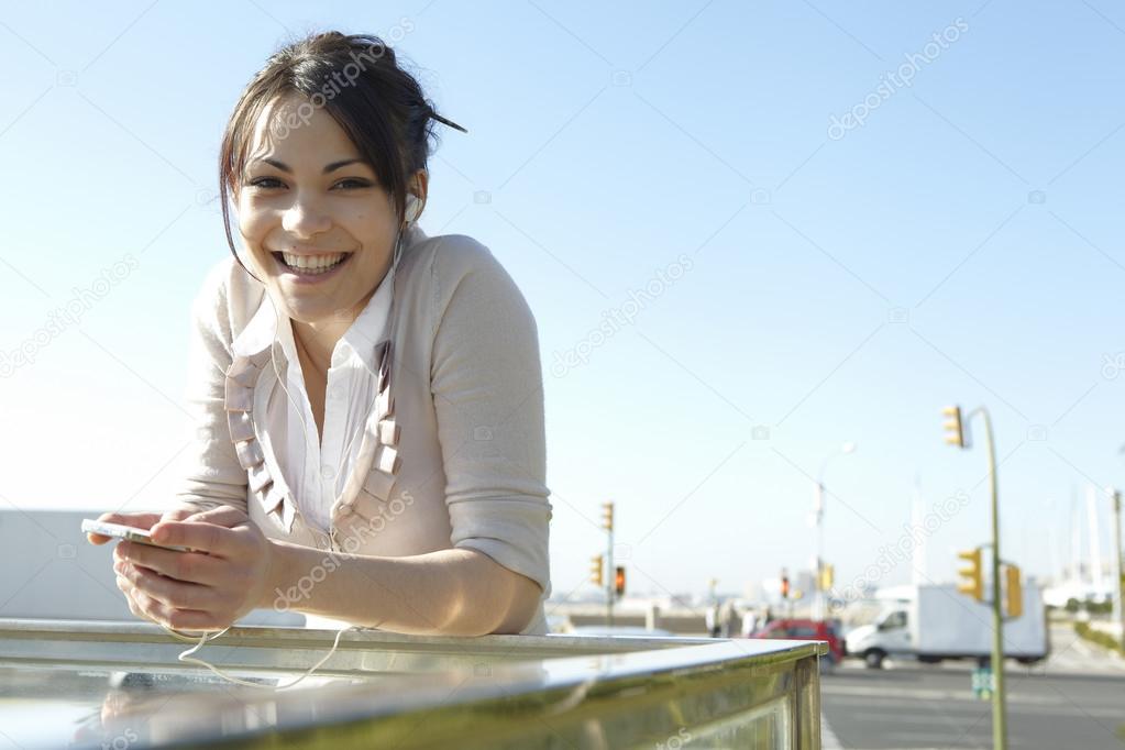 Young woman listening to music with headphones in the city