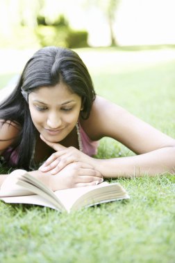 Hintli kız parkta yeşil çim döşeme