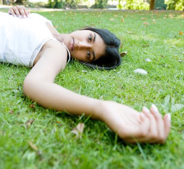 Hintli kız parkta yeşil çim döşeme