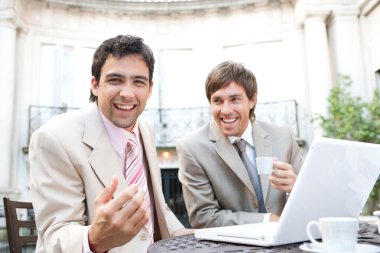 Two businessmen laughing while having a meeting clipart