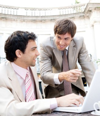 two businessmen having a meeting while sitting in a classic coffee shop terrace clipart