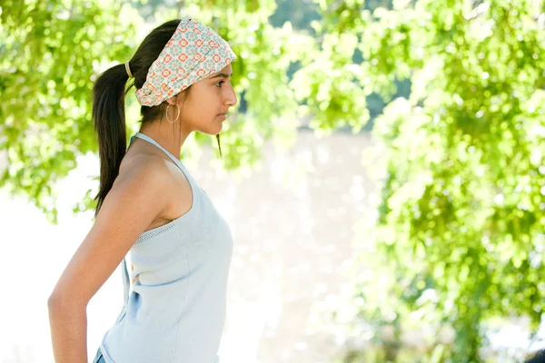 Profile view of an Idian girl standing by a lake on a sunny golden day. — Stock Photo, Image