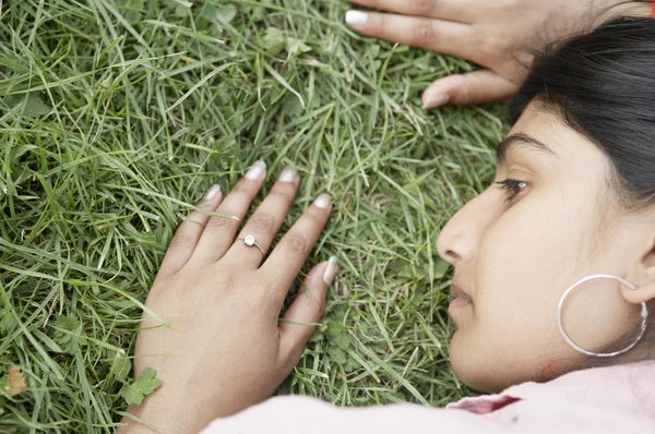 Rosto da menina indiana deitado na grama — Fotografia de Stock