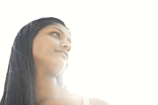 India chica contra el cielo con el sol ligth filtrando a través de su cuello . —  Fotos de Stock