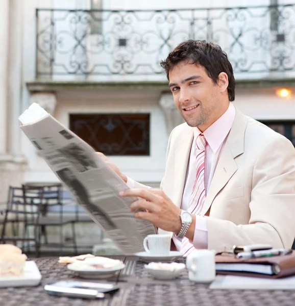 Young attactive hispanic businessman reading the newspaper — Stock Photo, Image