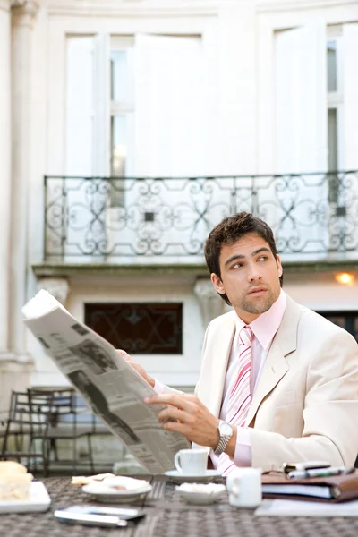 Attractive young businessman reading the newspaper — Stock Photo, Image