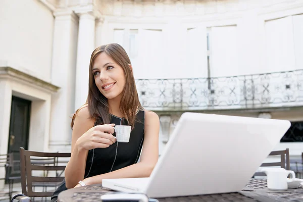 Ελκυστική επιχειρηματίας πίνοντας καφέ και χρησιμοποιώντας ένα φορητό υπολογιστή — Φωτογραφία Αρχείου
