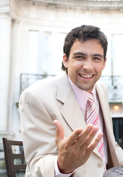 Young businessman talking and making gestures with his hand to the camera — Stock Photo, Image