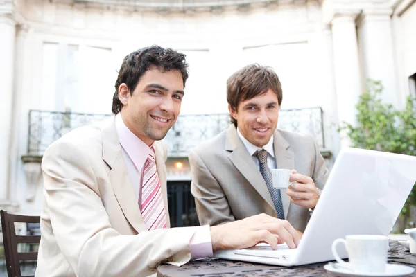 Twee ondernemers met een bijeenkomst zittend in een klassieke koffie shop terras — Stockfoto