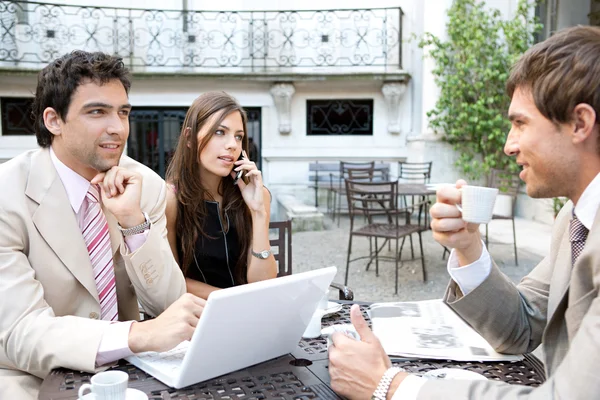 Tres negocios compartiendo mesa en la terraza de una cafetería —  Fotos de Stock