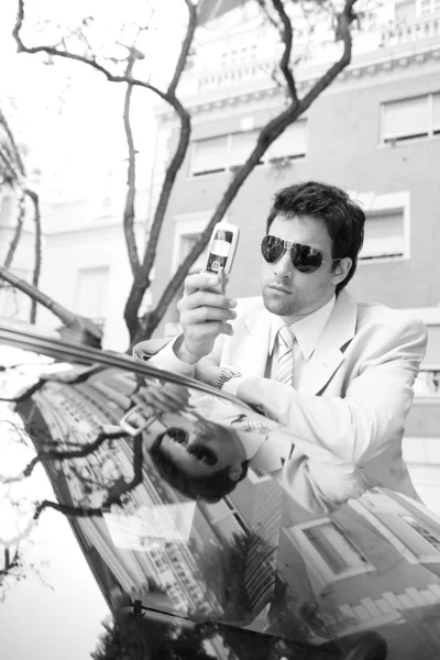 Black and white portrait of an attractive businessman using his cell phone — Stock Photo, Image