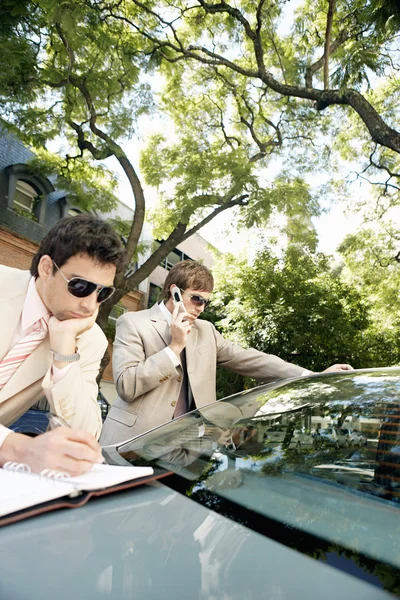 Deux hommes d'affaires attrayants se réunissant dans une rue bordée d'arbres — Photo