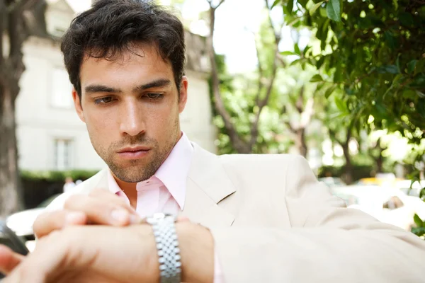 Giovane uomo d'affari attraente guardando il tempo nel suo orologio — Foto Stock