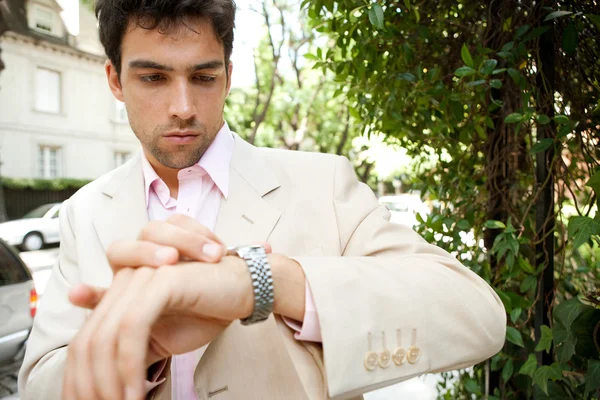 Joven empresario atractivo mirando la hora en su reloj — Foto de Stock