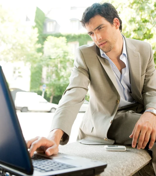 Jeune homme d'affaires attrayant utilisant un ordinateur portable — Photo