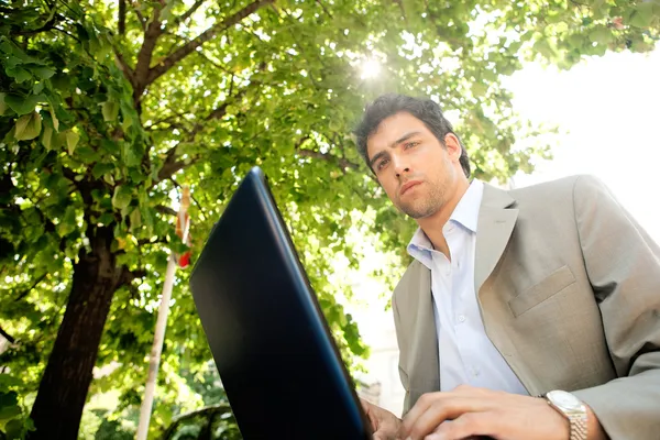 Attraktiv ung affärsman använder en bärbar pc dator — Stockfoto