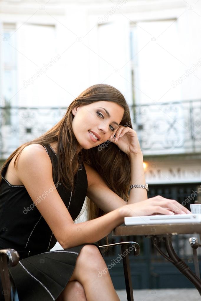 Attractive businesswoman using a laptop computer while sitting in a coffee shop