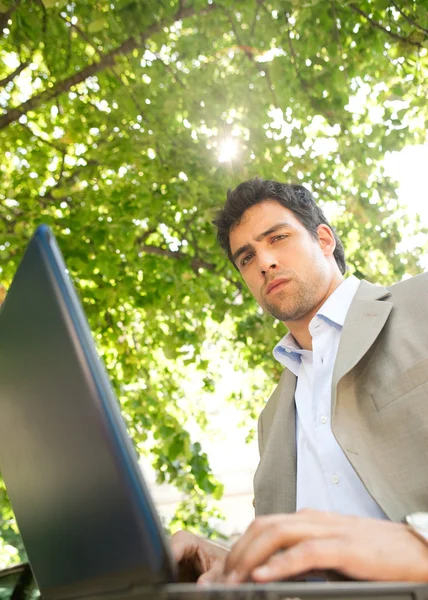 Attrayant jeune homme d'affaires en utilisant un ordinateur portable PC — Photo