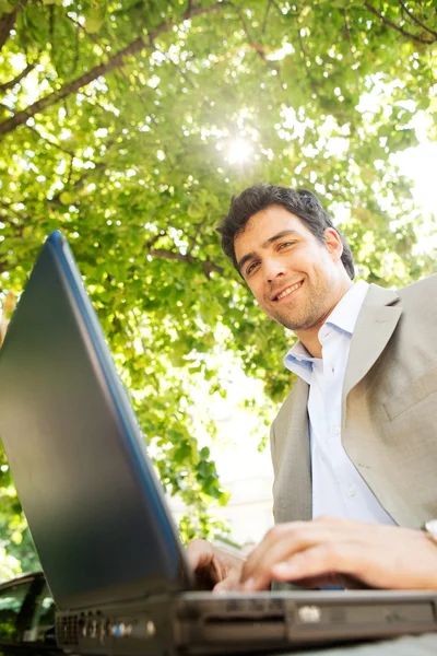 Attraktiv ung affärsman använder en bärbar pc dator — Stockfoto