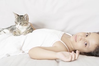 genç kız ve beyaz kanepede döşenmesi kedi.