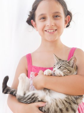bir kedi yavrusu kucağında tutan genç bir kızın portresi yukarıya kapatmak