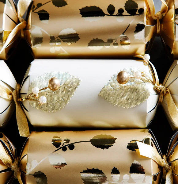 Three golden christmas crackers decorated with beads and ribbons — Stock Photo, Image