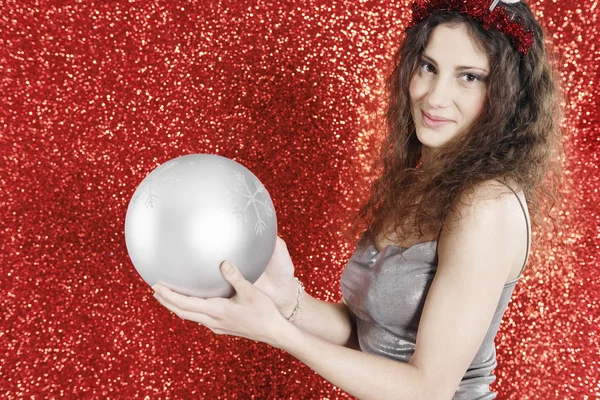 Menina atraente segurando uma grande bola de Natal — Fotografia de Stock