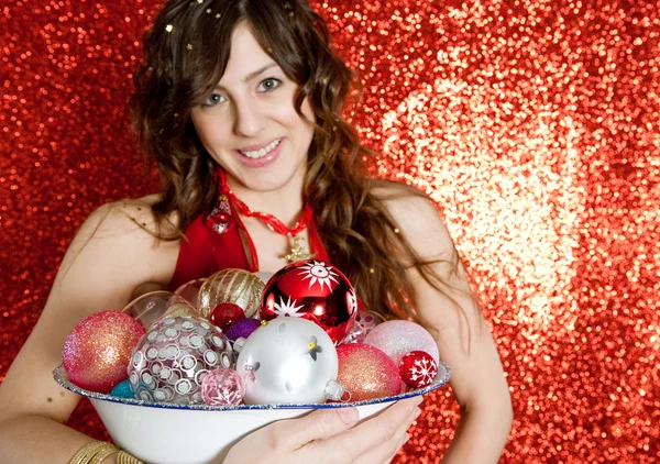 Mujer joven sosteniendo un plato lleno de bolas de bar de Navidad — Foto de Stock