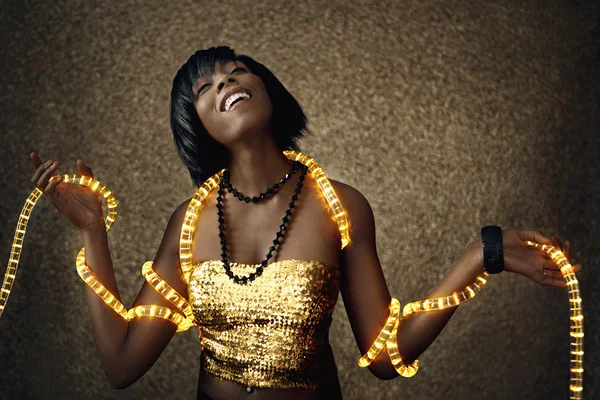 Attraktive schwarze Frau tanzt mit Weihnachtsbeleuchtung — Stockfoto