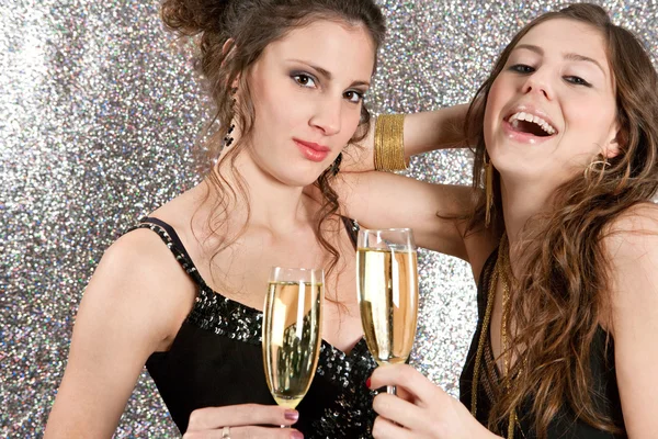 Dos mujeres jóvenes brindando con champán en una fiesta — Foto de Stock