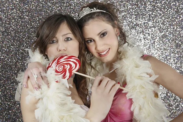Dos novias compartiendo una boa de plumas y comiendo dulces — Foto de Stock
