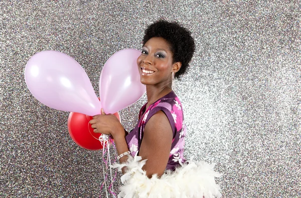 Atractiva joven mujer negra sosteniendo globos rosados y rojos — Foto de Stock